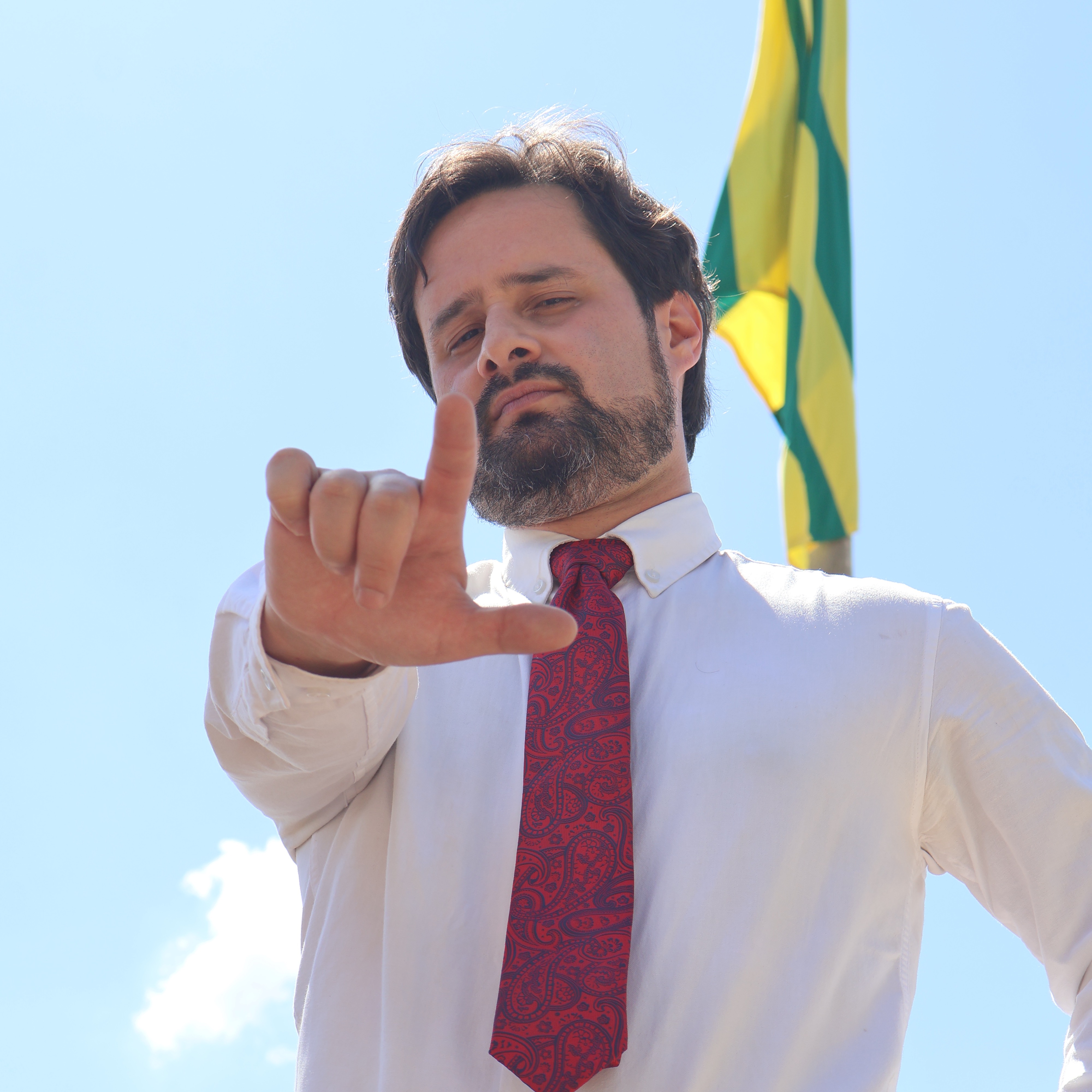 Valério Luiz diante da bandeira do Brasil